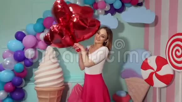 年轻漂亮女孩带红色气球的肖像视频的预览图