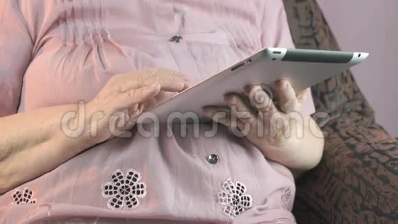 80多岁的老妇人手持银制平板电脑视频的预览图