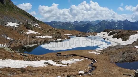 春季高山天然湖泊的鸟瞰图冰雪融化意大利阿尔卑斯山意大利视频的预览图