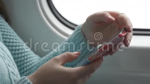 年轻女子坐火车和使用手机女性手从智能手机发送信息女孩的手臂视频的预览图