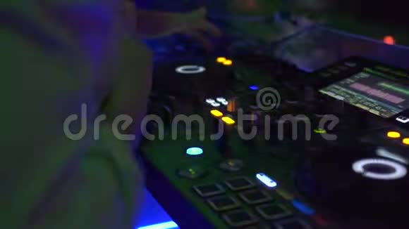 在夜总会的舞会上DJ控制器和音乐控制台在五颜六色的灯光下DJ调音台和音响控制台视频的预览图