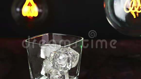 酒吧服务员在木桌上倒满冰块的威士忌温暖的气氛威士忌放松的时间视频的预览图