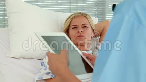 医生在病人病床前使用平板电脑视频的预览图