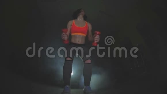 漂亮的健身女人举起哑铃运动女孩展示她训练有素的身体发达的肌肉视频的预览图