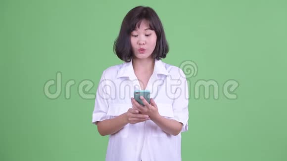 快乐美丽的亚洲女商人思考电话视频的预览图