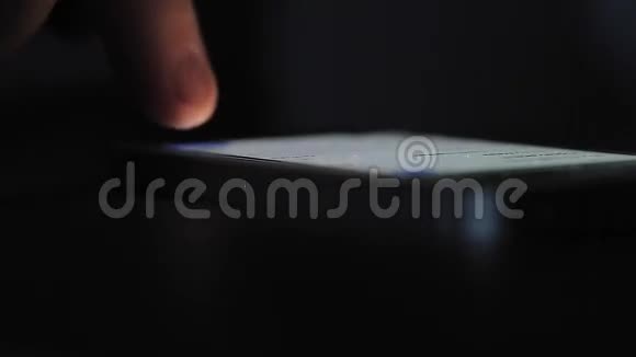 桌上的移动电话用手指刷洗视频的预览图