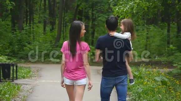 可爱的女婴和父母在公园散步视频的预览图
