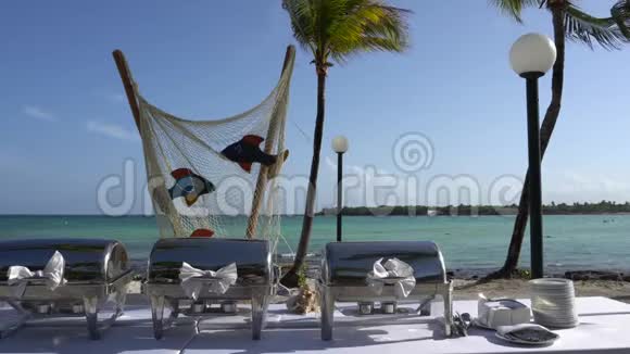 热带海岸豪华度假酒店海滩景观椰子树的叶子随风飘动在蓝天上视频的预览图