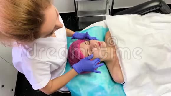 为在美容院戴面膜的年轻女性提供水疗疗法视频的预览图