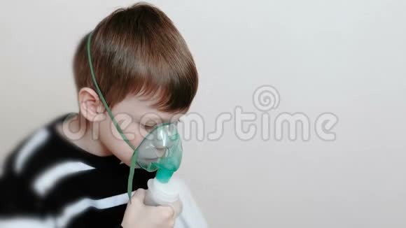 使用雾化器和吸入器进行治疗男孩通过吸入器面罩吸入侧视视频的预览图