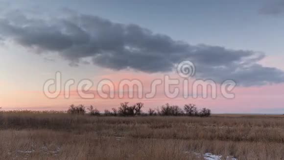 时光流逝俄罗斯在冬天的雪原中日落时云彩的运动视频的预览图