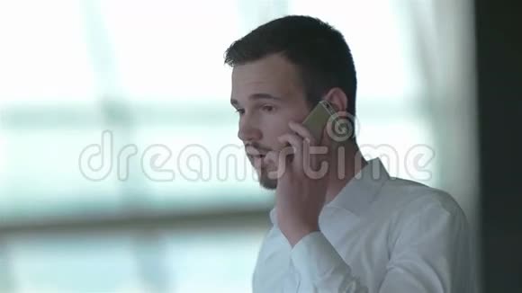 一位轻松的年轻商人在智能手机上讲话视频的预览图
