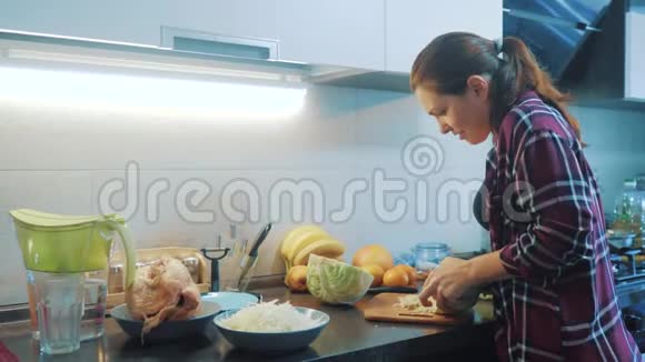 厨房里的女人在准备一种膳食概念的生活方式厨房里的女孩用刀切卷心菜做素食者视频的预览图