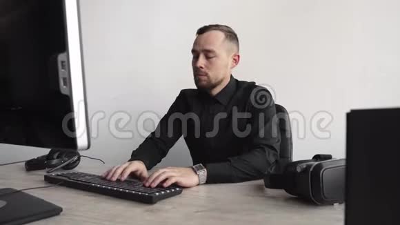 年轻的商人或穿着衬衫坐在电脑显示器旁的学生在办公室的一张桌子上工作视频的预览图