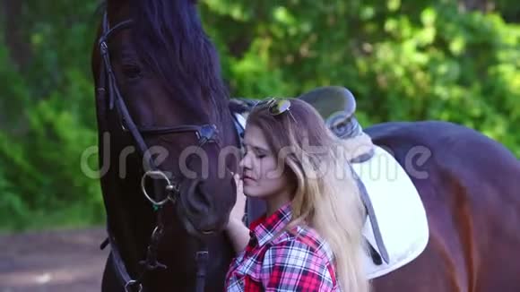 年轻的金发女人穿着格子衬衫和他的马一起散步视频的预览图