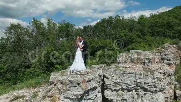 新郎新娘在岩石上接吻视频的预览图