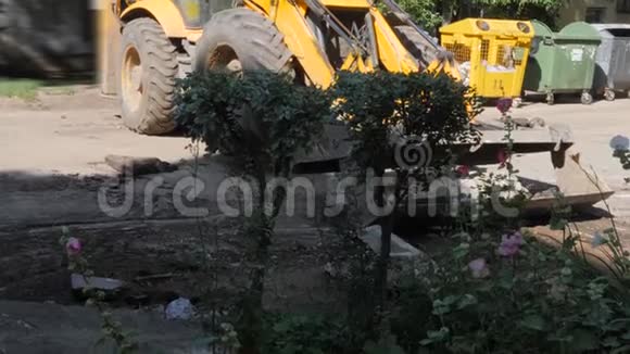 在铺设新的沥青之前一辆拖拉机将住宅建筑庭院中的建筑清除掉视频的预览图