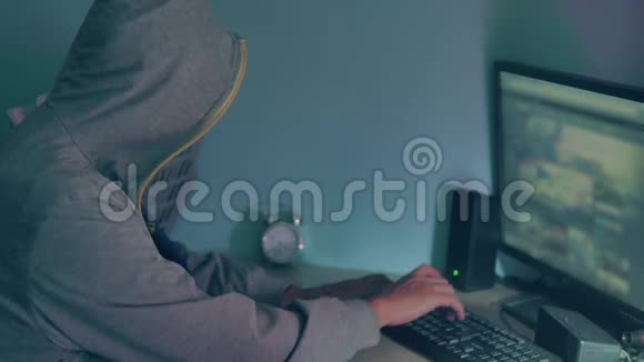 男性黑客在电脑上工作一个黑客把他的脸藏在室内视频的预览图