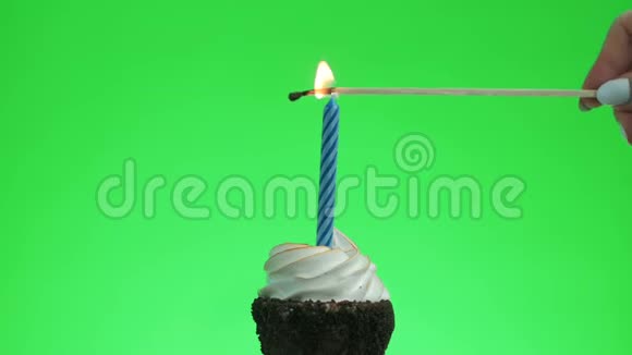 在美味的蛋糕上点燃一支蓝色的蜡烛绿色的屏幕视频的预览图