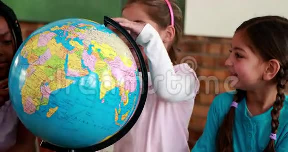 可爱的学生在教室里微笑着环游地球视频的预览图