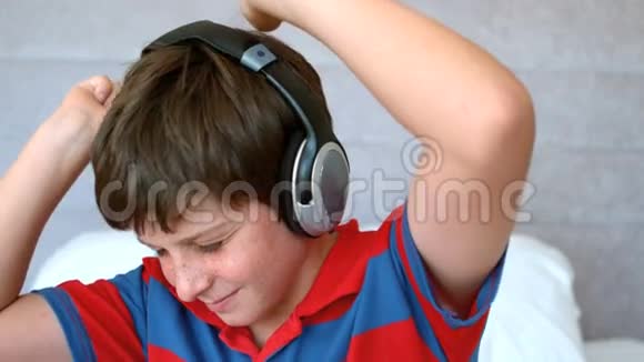 小男孩带着耳机欣赏音乐视频的预览图
