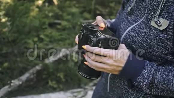 游客在森林中拍摄风景一个高加索女人近距离射击女孩在dslr上拍照视频的预览图