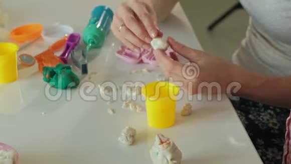 一个年轻的女人和一个女孩用塑料制成牙齿把牙齿插入玩具下巴扮演一个牙医母亲和视频的预览图
