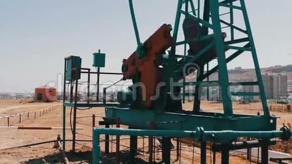 阿塞拜疆巴库一个工作油田的一部分油井工作油泵和一个生锈的旧铁的剪影视频的预览图