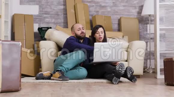 一对夫妇坐在新公寓的地板上视频的预览图