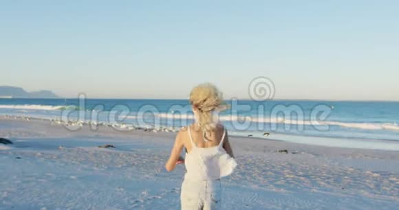 在海滩上奔跑的年轻女子视频的预览图