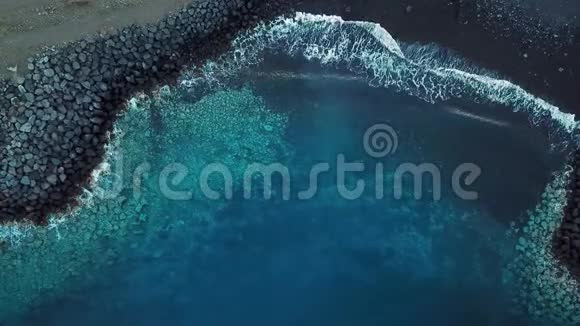 俯瞰一片荒芜的黑色火山海滩特内里费岛海岸空中无人机拍摄的海浪到达视频的预览图