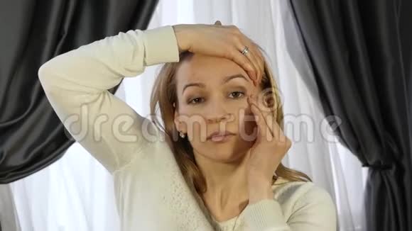 家庭自我按摩女性在辛苦工作后做面部按摩视频的预览图