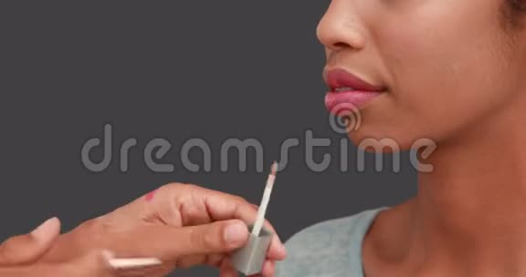化妆师在模特脸上涂上唇彩视频的预览图