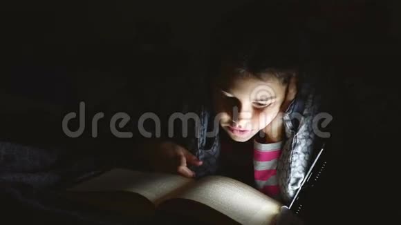十几岁的女孩晚上用手电筒在毯子下面看书视频的预览图