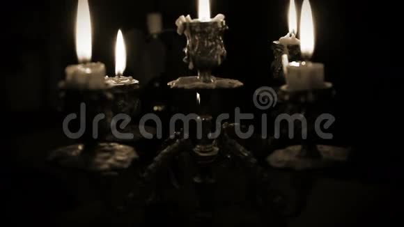 蜡烛在烛台上五根树枝在黑暗中视频的预览图
