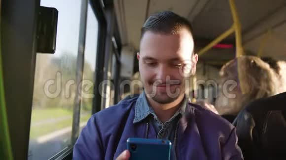 一个年轻人在公共汽车上使用智能手机视频的预览图