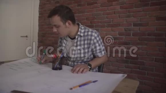 自信的年轻有魅力的集中男人穿着格子衬衫在商业项目上工作坐在木桌旁思考问题视频的预览图
