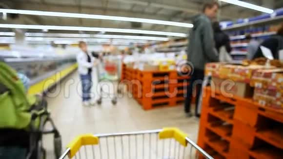 在大型超市里移动购物车视频的预览图