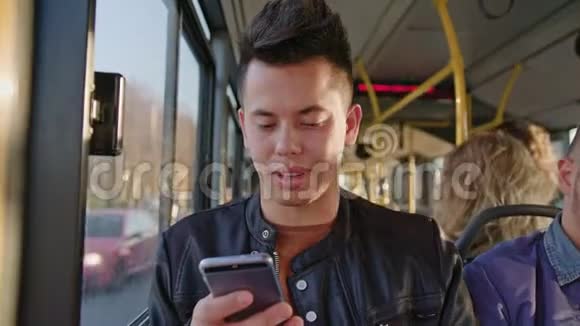 一个年轻人在公共汽车上使用智能手机视频的预览图