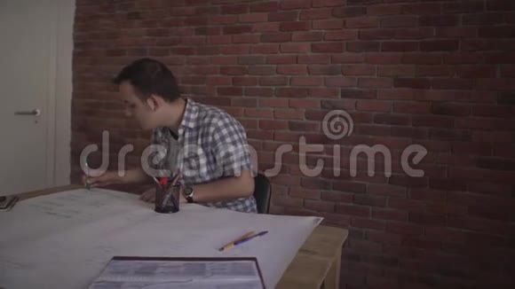 有魅力的年轻集中精力自信的男人穿着格子衬衫做着商业项目坐在木桌上思考问题视频的预览图