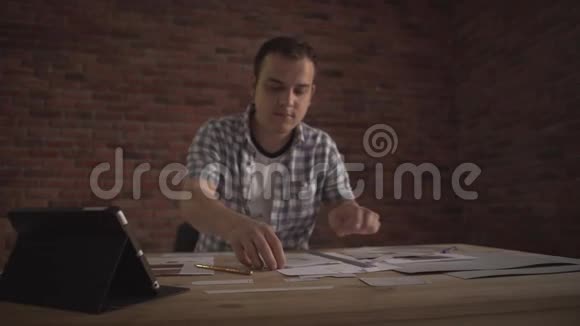 年轻有魅力精力充沛自信的人穿着格子衬衫在商业项目中工作坐在木桌上思考问题视频的预览图