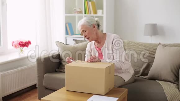 年长妇女在家打开包裹盒视频的预览图