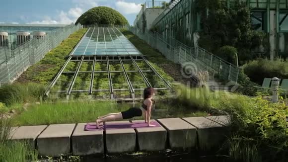 穿黑色运动服的年轻女孩在户外做瑜伽做各种运动视频的预览图
