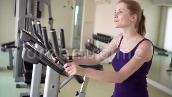 漂亮的适合年轻女子在健身房做运动的天鹅绒模拟器视频的预览图