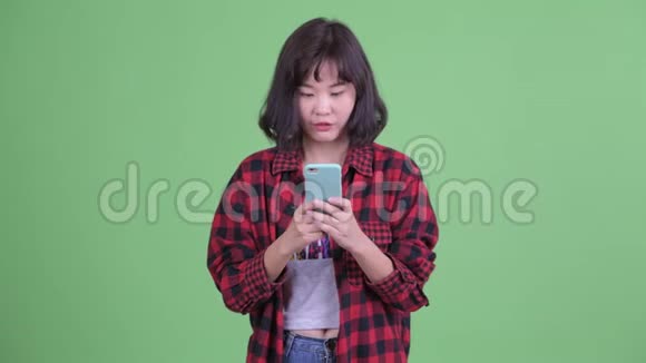 快乐的亚洲时髦女人用电话视频的预览图