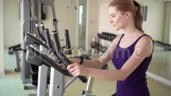 漂亮的适合年轻女子在健身房做运动的天鹅绒模拟器视频的预览图