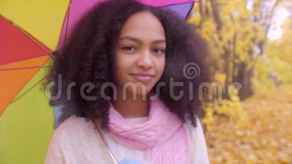 秋天公园有彩色雨伞的可爱少女视频的预览图