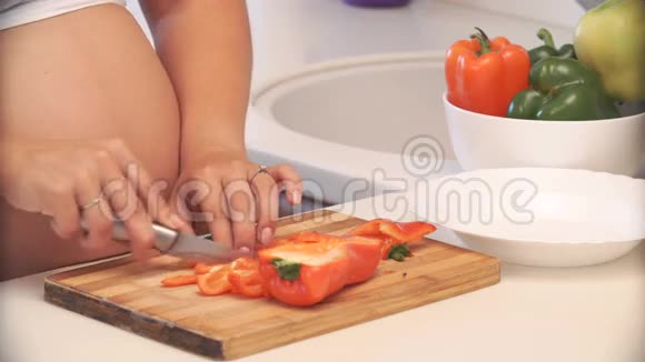 孕妇在厨房里切胡椒蔬菜沙拉视频的预览图
