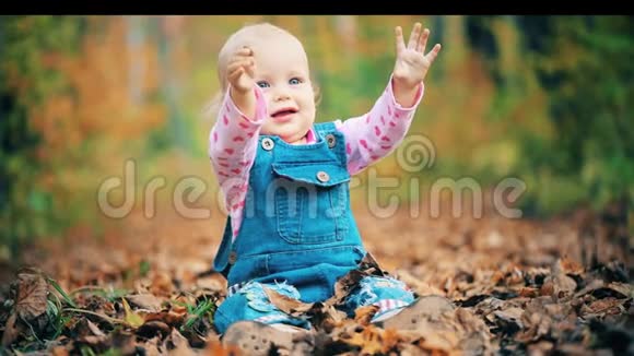 快乐的女婴在秋天的森林里嬉笑打闹视频的预览图