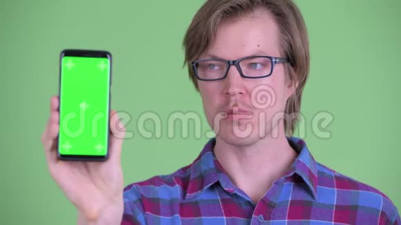 年轻英俊的嬉皮士展示电话的脸视频的预览图